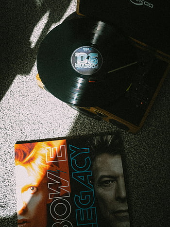 David Bowie, vinyl record, vintage record player, dramatic lighting, retro aesthetic, album cover, music, legacy, 90s, turntable, dramatic shadows