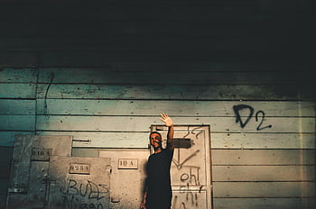 mladý muž, krycí obličej, slunečního světla, graffiti zeď, městském prostředí, Móda streetwear, pouliční styl, venkovní portrét, příležitostná pozice, městské pozadí, pouliční umění