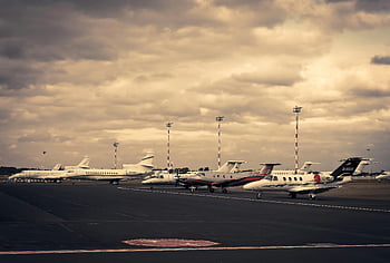 private jets, tarmac, dramatic sky, aviation, travel, parked jets, cloudy sky, airport scene, luxury travel, aircraft lineup, jet line