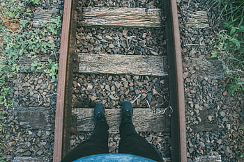 jeans aderenti neri, scarpe da ginnastica, sentiero di legno, binari ferroviari, dintorni rocciosi, Railway rustico, persona in piedi, jeans aderenti, scarpe da ginnastica nere, ferrovia di legno, sentiero roccioso
