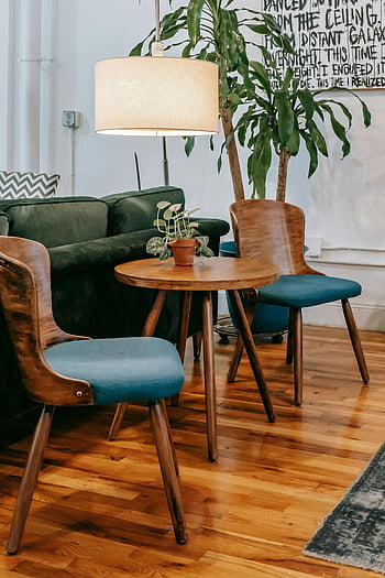 útulný obývací pokoj, dřevěné židle, dřevěný stůl, modré židle, zelené akcenty, moderní obývací pokoj, Elegantní interiér, dřevěný nábytek, pokojové rostliny, dřevěná podlaha, útulný interiér