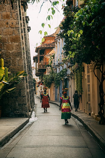 women on street, Colombia, Cartagena, traditional attire, historic architecture, colorful street scene, women in Colombia, street life, cultural heritage, vibrant colors, colonial buildings