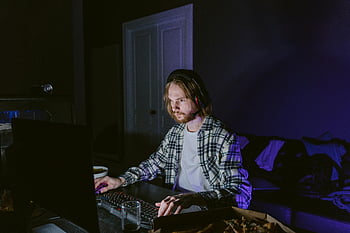 man in plaid shirt, playing video game, computer gaming, headphones, dark room, screen light, gaming setup, plaid shirt, video games, computer, headphones on