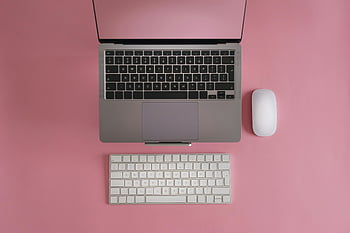 laptop, mouse, keyboard, pink surface, tech content, top view, computer setup, workspace, tech-related, minimalist, desk arrangement