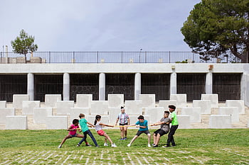 kids playing tug of war, park, stone wall backdrop, outdoor game, children, lively game, tug of war, park activities, group activity, outdoor fun, kids enjoying