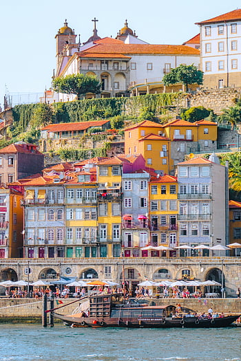 Porto waterfront, colorful buildings, historic buildings, traditional boat, vibrant view, Porto Portugal, waterfront view, colorful historic buildings, traditional Portuguese boat, Porto cityscape, Douro river