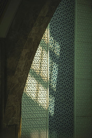 intricate wall pattern, sunlight casting shadows, architectural design, geometric patterns, decorative wall, intricate design, sunlight shadow effect, architectural photography, patterned sunlight shadows