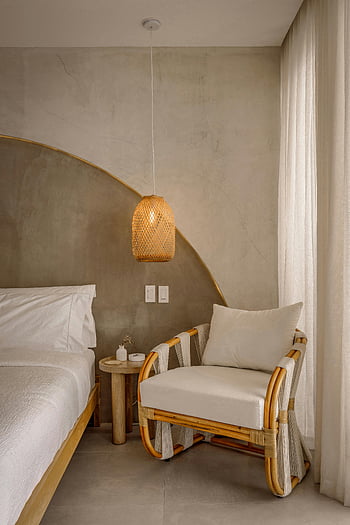 cozy modern bedroom, rattan chair, rattan lamp, chic bedroom interior, warm lighting, soothing ambiance, rattan furniture, modern bedroom design, cozy bedroom, modern rattan furniture, warm bedroom lighting