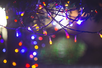 multi-colored string lights, colorful Christmas lights, festive mood, warm glow, dark setting, holiday decor, string lights, Christmas decorations, bokeh effect, festive lighting, holiday lights