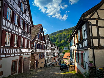 Old Town, traditional design, Alemannic timber-framed houses, scenic hillside town, charming street, historic buildings, European architecture, picturesque village, half-timbered houses, rural landscape, blue sky