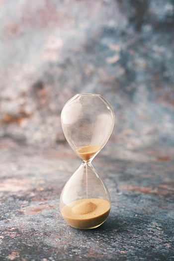 hourglass, clear hourglass, concrete surface, decorative textured surface, passage of time, sand timer, elegant hourglass, time symbol, sand flow, vintage background, minimalist design