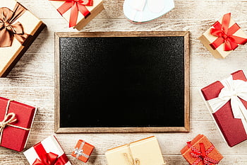 chalkboard, brown wooden frame, red gift boxes, flat lay, colorful gift boxes, ribbons, blank blackboard, holiday season messaging, festive decorations, gift wrapping, wooden table
