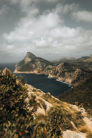 Cap de Formentor, Mallorca, Spain, aerial view, rugged cliffs, serene coastline, cloudy sky, natural landscape, coastal scenery, Balearic Islands, Mediterranean sea