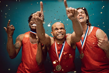 Sportovci nosí medaile, Oslava vítězství, medaile, konfety, modré pozadí, tři sportovci, Sportovní vítězství, Atletický úspěch, Vítězové medaile, Oslava konfet, Sportovní oslava