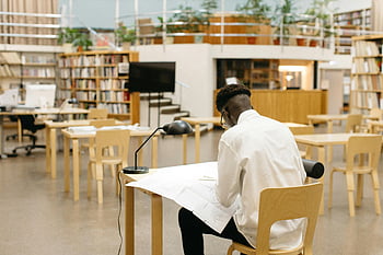 رجل صياغة،  مكتبة،  طالب يدرس،  مكتب،  مكتبة حديثة،  أرفف الكتب،  مساحة مفتوحة،  بيئة الدراسة،  الإعداد الأكاديمي،  المكتبة الداخلية،  مساحة العمل