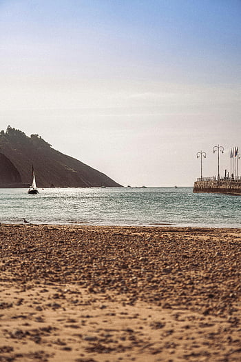 vue sur l'océan, plage tranquille, voilier au large, Promenade en bord de mer, scène de plage, eaux calmes, paysage côtier, rivage sablonneux, vue sur la mer, plage paisible, paysage océanique