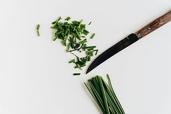 garlic chives, chopped chives, fresh chives, white background, cooking concepts, knife, green herbs, culinary ingredients, food photography, herb preparation, close-up photo