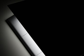 černé pozadí, Moderní notebook, elegantní design, stín, detailní pohled, částečný pohled, notebook uzavřen, minimalistický design, Temná estetika, technologie, moderní zařízení