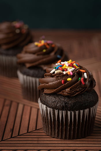 chocolate cupcakes, sprinkles, rich frosting, colorful sprinkles, three cupcakes, chocolate frosting, dessert, sweet treat, bakery, cupcake, chocolate cake