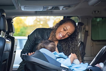 woman, child, car seat, vehicle, joyful mother, baby, smiling, inside car, family moment, travel safety, parenting