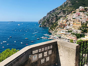 Positano, rocky sea coast, vibrant houses, boats, sunny day, coastline, Amalfi Coast, Italy, hillside houses, Mediterranean, picturesque view