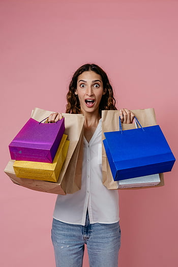 woman holding shopping bags, colorful shopping bags, young woman, studio photo, pink background, surprised expression, casual outfit, shopping haul, lifestyle photography, retail therapy, consumerism
