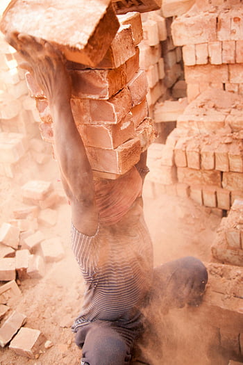 worker, bricks, dusty environment, hard physical work, stack of bricks, construction site, manual labor, dusty conditions, heavy lifting, construction worker, dusty workplace