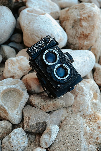 Vintage Yashica-kamera, Teksturerede klipper, nærbillede fotografering, Fotograferingsentusiaster, Yashica Måtte-124G, vintage kamera, udendørs fotografering, Rocksteksturer, kamera på klipperne, nærbillede skudt, retro kamera
