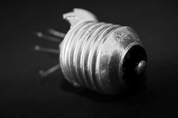 aluminum electrical bulb, component, monochrome image, broken lightbulb, dark background, intricate details, black and white, bulb base, electrical component, close-up, macro photography