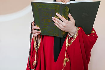 žena v červené barvě, tradiční oblečení, hospodářství kniha, modlitební korálky, čtení koránu, Islámská oddanost, náboženské praxe, Kulturní oděv, duchovní čtení, Svatá kniha, modlitební korálky v ruce
