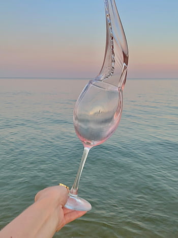 rose wine, wine glass, ocean sunset, elegant splash, serene ocean, art and nature, wine splashing, sunset backdrop, wine photography, beach scene, wine moment