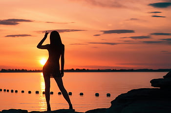 sunset silhouette, woman silhouette, sea sunset, vibrant sunset, tranquility scene, body of water, seaside sunset, sunset photography, peaceful sunset, sunset by the sea, woman near water
