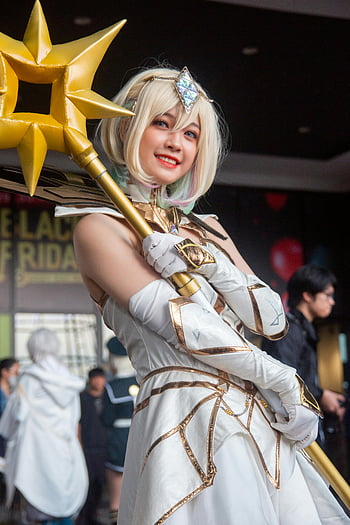 cosplay, smiling woman, detailed costume, staff, convention, indoors, cosplayer, white outfit, gold staff, anime character, cosplay event