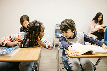 Elementaire studenten, klaslokaal, chatten, communicatie vaardigheden, Twee studenten, roddelen, bureaus, boeken, leeromgeving, wisselwerking, opleiding