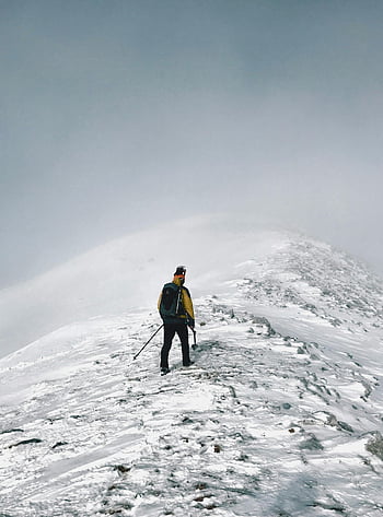 person on top of mountain, lone hiker, snow-covered mountain, Albania, winter adventure, trekking, snow, mountain peak, adventure, winter chill, hiker with backpack
