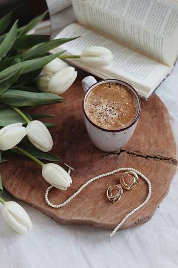 kaffe, fladt læg, hvide tulipaner, åben bog, smykker, træbakke, Varm æstetik, kaffekop, perlehalskæde, guldringe, Hyggelig opsætning