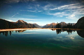mountain lake, serene dawn, clear reflections, vibrant sky, body of water, mountain view, natural landscape, tranquil scene, outdoor scenery, alpine lake, dawn view