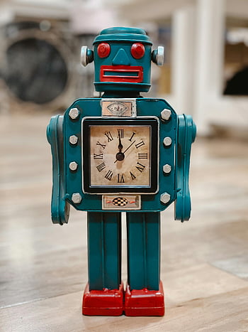 Blue and Red Robot Clock, vintage robot clock, roman numerals, wooden floor, retro clock, robot-shaped clock, indoor room, decorative clock, antique clock, blue robot, red robot