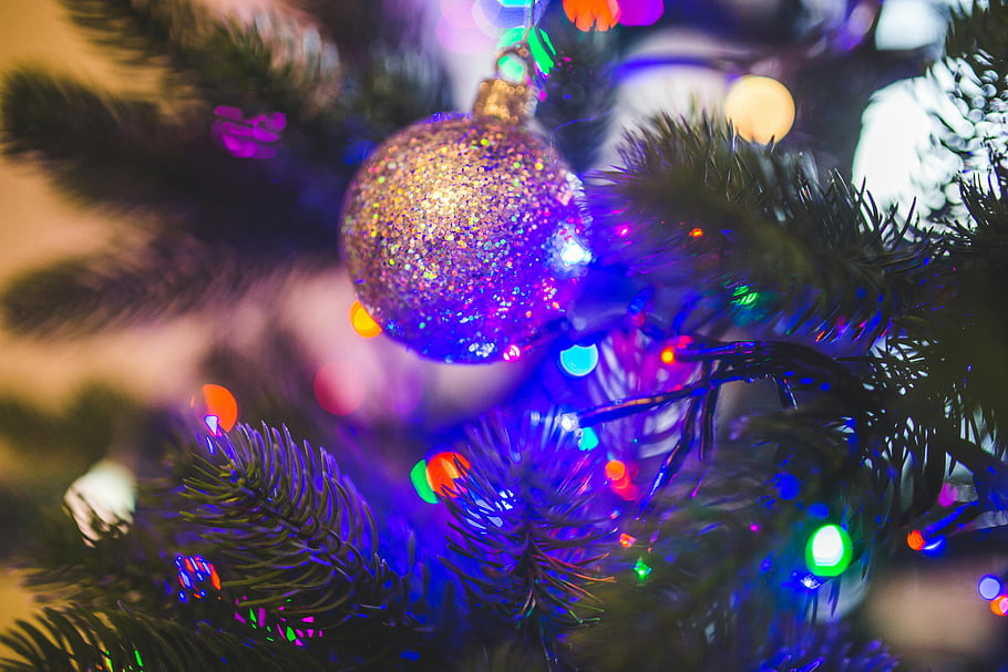 bal, groene kerstboom, glinsterend ornament, kleurrijke kerstboom, close-up ornament, feestelijke decoratie, vakantie decor, kerstlichten, glitter ornament, boomtak, feestelijk seizoen