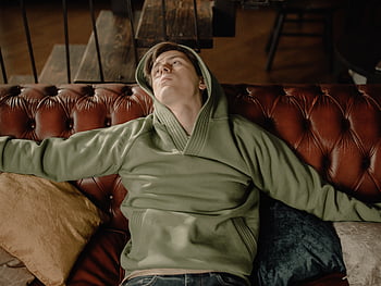 mand, grøn hættetrøje, slapper af, lædersofa, hyggeligt hjem, brun læder sofa, komfortabel, indendørs indstilling, afslappet tøj, Hjemstemning, puder