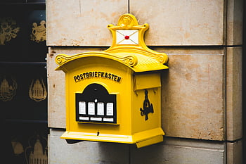 Cassetta postale gialla, cassetta delle lettere d'epoca, postbriefkasten, cassetta postale galleggiante, muro di cemento marrone, design ornato, muro di pietra, Post -box gialla, Post -box vintage, cassetta postale decorativa, Cassetta postale montata a parete
