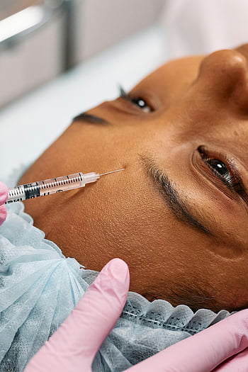 미용 절차, 바늘 주입, 이마 주입, 클로즈업 이미지, 얼굴 처리, 미용 치료, 의료용 장갑, 주사기, 노화 방지 치료, 피부 관리, 미적 절차