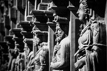 grayscale photography, statues, black and white, historic stone sculptures, intricate craftsmanship, stone carvings, monochrome art, architectural details, cultural heritage, ancient art, sculpture collection