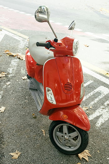 rød motor scooter, bylivsstil, Parkeret scooter, faldne blade, gadescene, knaldrød, scooter, bymæssige omgivelser, efterårsblade, byens gade, motorcykel