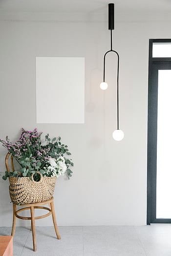 wilde bloemen, rieten mand, modern interieur, bloemstuk, hanglampen, Wit Mockup, stijlvol decor, interieur ontwerp, moderne verlichting, witte muur, houten stoel