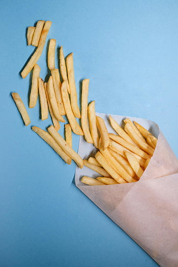 fried potatoes, French fries, crispy fries, paper, blue background, spilling fries, bright blue, snack food, fast food, potato sticks, food photography
