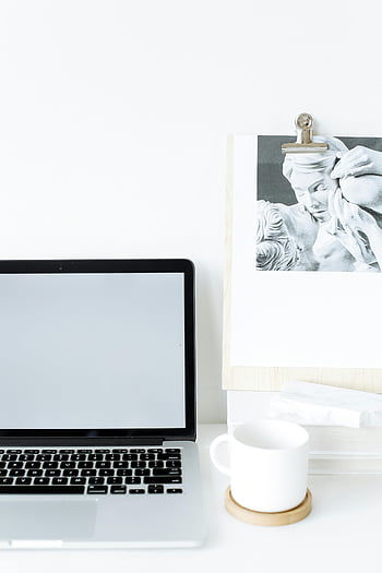 Moderní notebook, lavice, hrnek na kávu, minimalistický pracovní prostor, jasné nastavení, Umělecká schránka, elegantní design, nastavení pracovního prostoru, bílý stůl, Otevřený notebook, Světlé prostředí