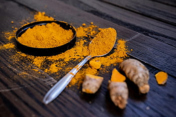 turmeric powder, vibrant turmeric, turmeric root, dark wooden surface, natural spices, close-up shot, turmeric spice, wooden background, spice photography, turmeric benefits, turmeric health