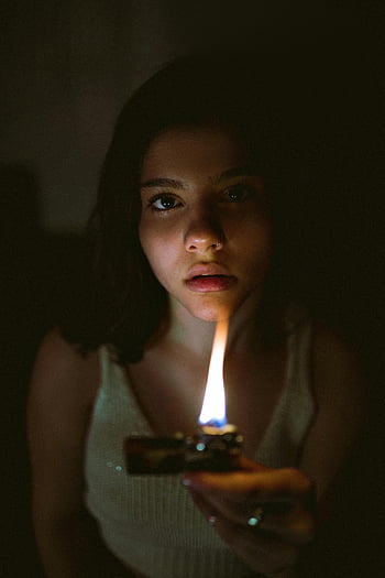 kvinde, flip lighter, Dramatisk glød, svagt oplyst rum, ansigtsbelysning, portræt, indendørs, flamme, håndhold, tæt på, humør belysning