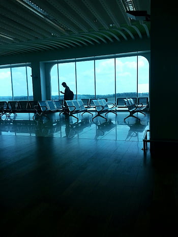 airport terminal, grey waiting chairs, silhouette of a person, large windows, seating, waiting area, travel, airport lounge, modern architecture, indoor space, reflective floor